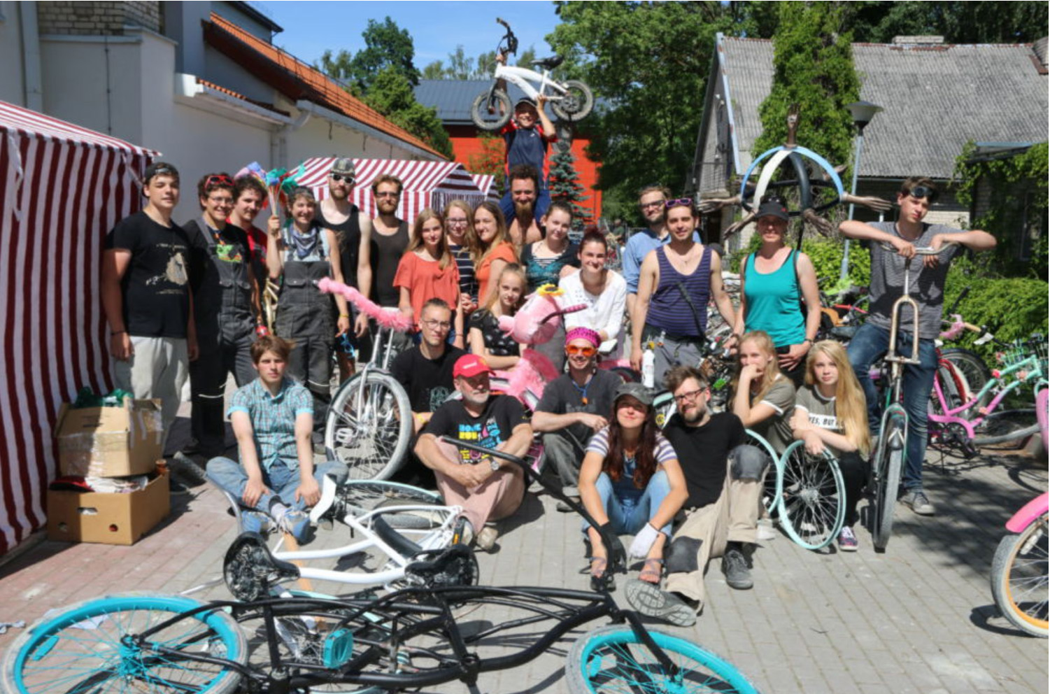 a group of young bicycle modifiers assemble with their creations in a group photo